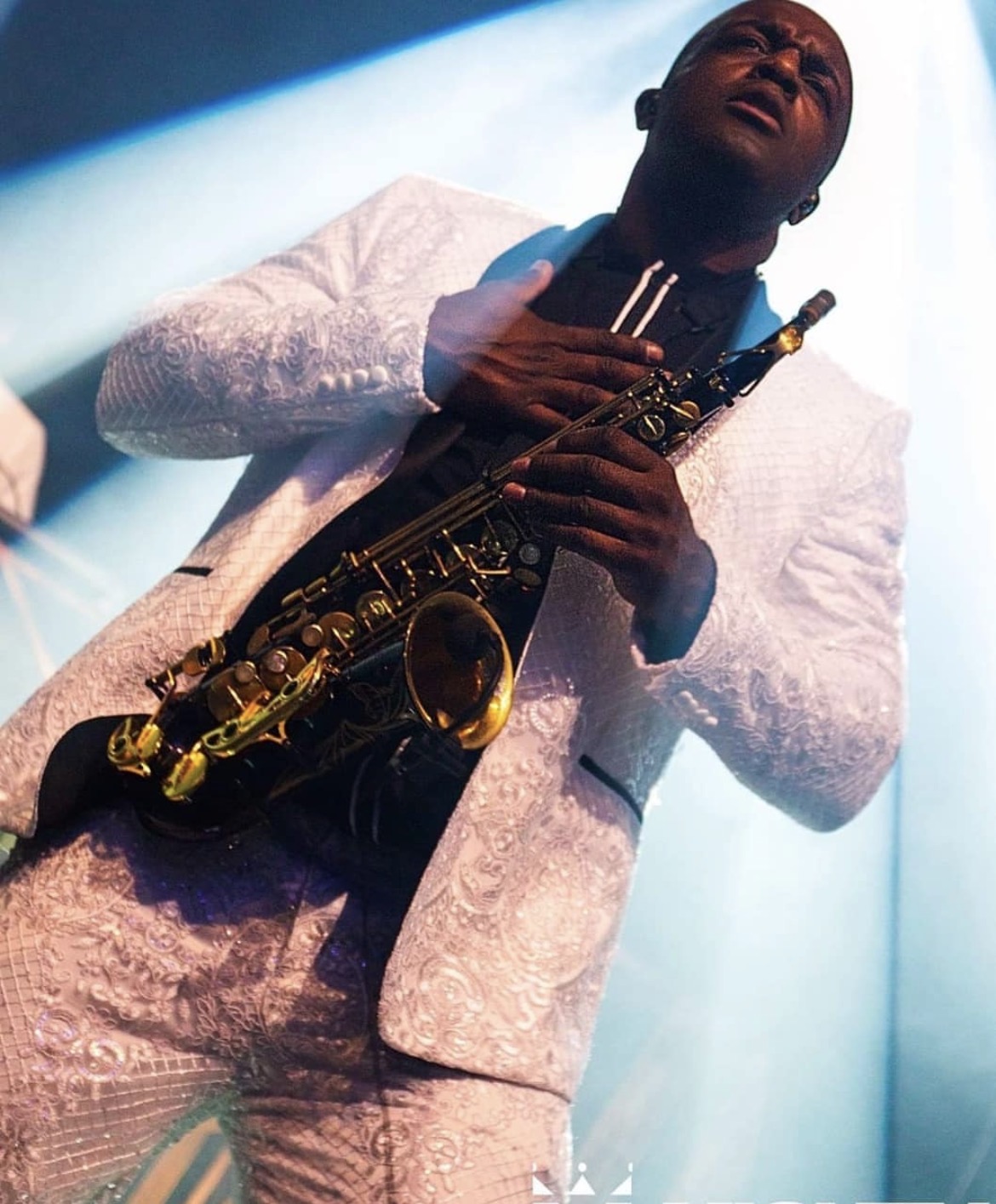 Dan Blaax performing live saxophone in white embroidered suit